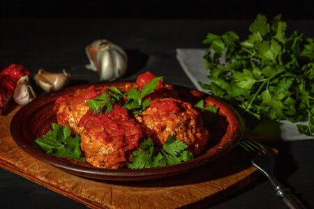 Delicious minced meatballs in spicy tomato sauce served on a clay dishの写真素材