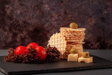 On a serving board, crispy wheat flour wafers with lettuceの写真素材