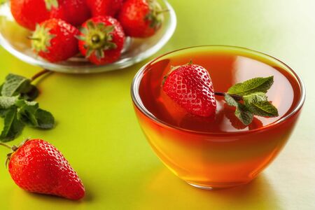 On a green table, fruit jelly with strawberriesの写真素材