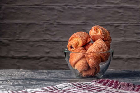 Freshly baked homemade puffs with aromatic coffee on a gray background