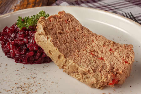 Chicken terrine with beet jam and parsley on the table on a platter