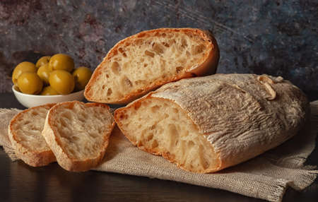 Fresh italian ciabatta bread with herbs, olive oil and olivesの写真素材