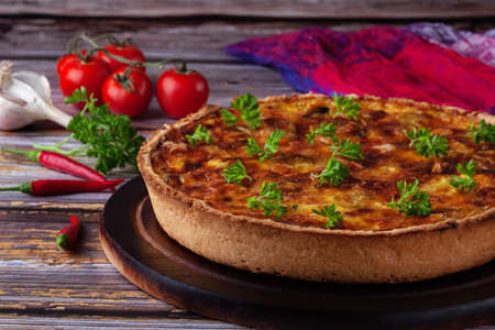 Traditional french quiche pie with chicken and mushroom on a wooden backgroundの写真素材