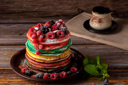 Colored pancakes with fruit, almonds and powdered sugar.の写真素材