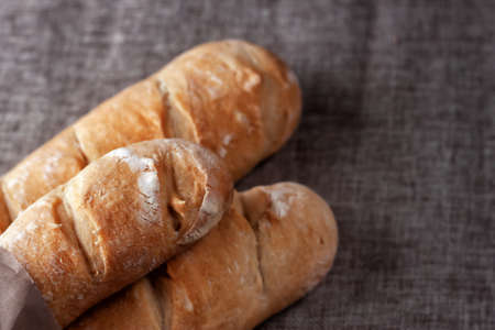 Freshly baked French baguettes on a table covered with cloth. Selective focus.の写真素材