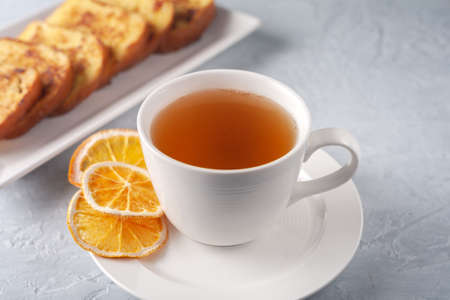 A cup of tea with dried orange and French toast. The concept of a healthy breakfast.の写真素材