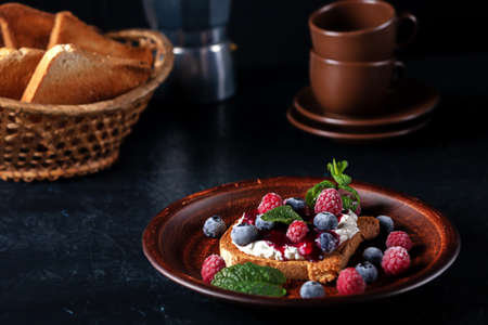 Bruschetta with cheese, jam and fresh raspberries and blueberriesの写真素材