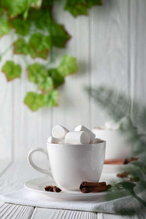 Mug with hot chocolate and marshmallows on wooden tableの写真素材