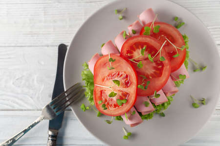 Sandwich with sausage, tomatoes, lettuce and microgreens. Light European breakfast.の写真素材