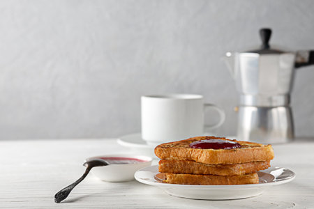 Toasted bread with jam and a cup of hot coffee on a wooden tableの写真素材