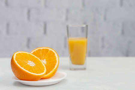 Sliced orange on a saucer with a glass of orange juiceの写真素材