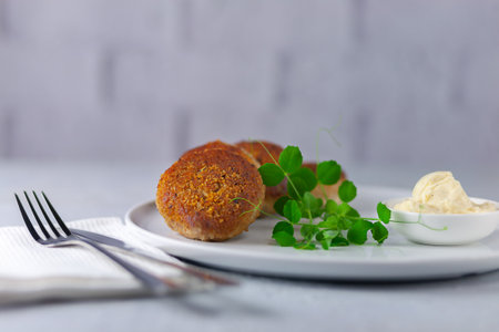 Fish cutlets with mayonnaise on a white plate.
