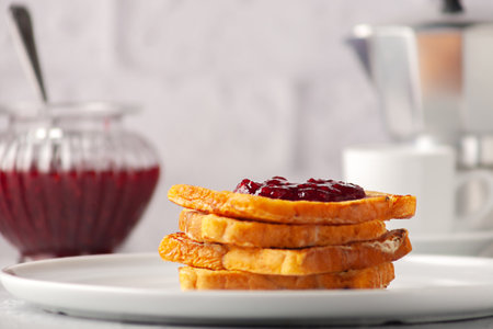 European breakfast. Toasted bread with jam and a cup of hot coffee on a wooden tableの写真素材