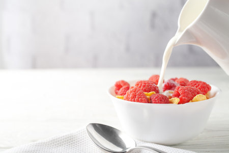 Delicious corn flakes with raspberries on a white wooden background. Fresh healthy food.の写真素材