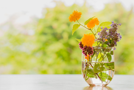 spring flowers in a glass vase on a tableの写真素材