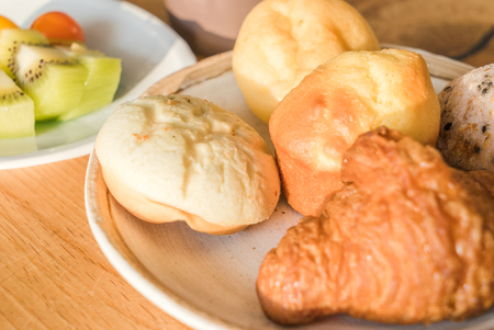 Bread and lots of fresh bread buns on a wooden table