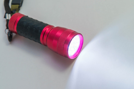 Red metal LED flashlight isolated on the white backgroundの写真素材