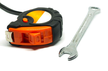 Wrench and tape measure on white background