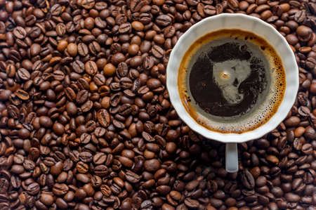 cup of coffe on coffe beans backgroundの写真素材