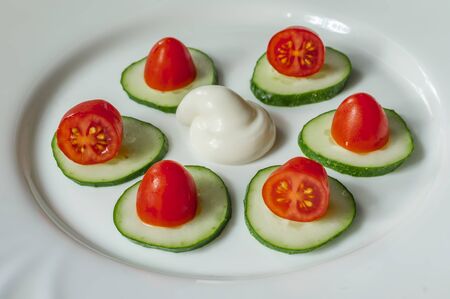 cucumbers, cherry tomatoes and sauÑe on a white plateの写真素材