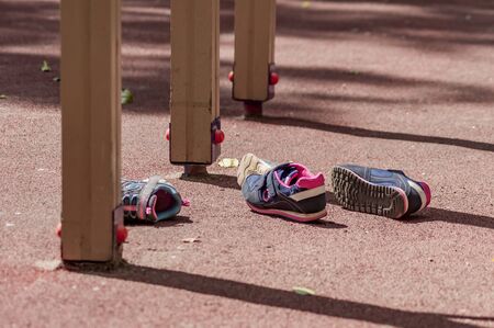 two pairs of childrens' sneakers lies on the playgroundの写真素材
