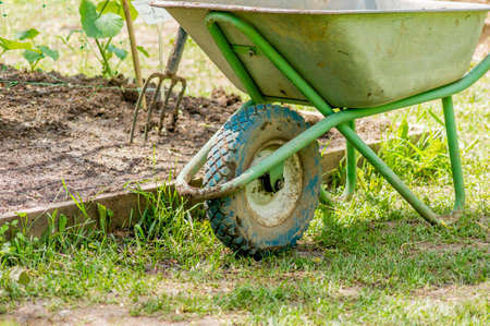 garden wheelbarrow near garden bed and tools