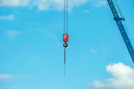 arrow and hook of the crane againsy blue skyの写真素材