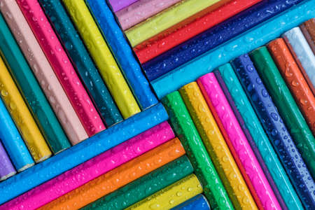 colored pencils background with drop of water