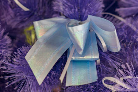 Closeup of Christmas-tree decoration. Decorative purple bow-knot in a fur treeの写真素材