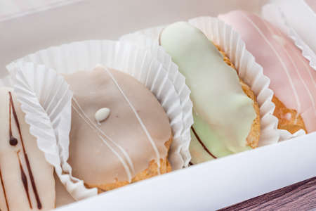 closeup of french eclairs in white box on wooden tableの写真素材