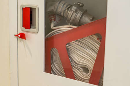ydrant with water hoses and fire extinguish equipment on the wallの写真素材