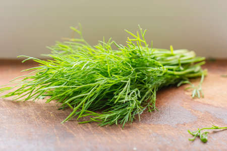 green dill on cutting desk, soft focus