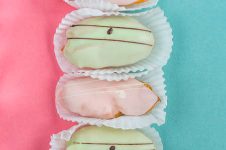 raspberry and pistachio eclairs on blue and pink background