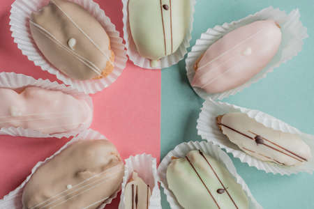 raspberry, chocolate and pistachio eclairs on blue and pink background