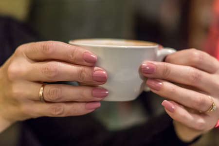 cup of cappuccino in woman handsの写真素材