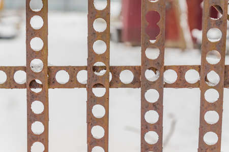 perforated fence on snow background.の写真素材