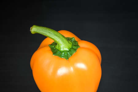 orange bell pepper on black background, copy space for your text