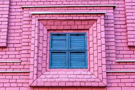 window closed with wooden shutters on brick wall backgroundの写真素材