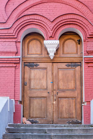 Wooden vintage closed door with brick wallの写真素材