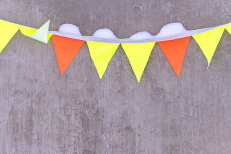  colorfull flags garland with snow on  concrete wall backgroundの写真素材