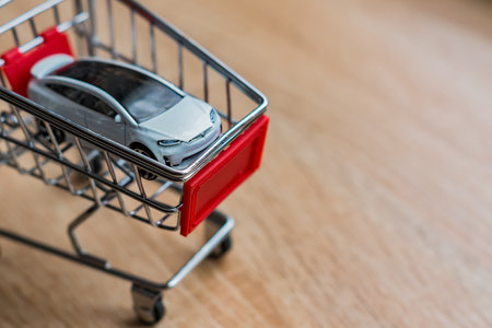Moscow, Russia - February 17, 2018: Toy car Tesla model X in small shopping cart. Concept with copy spaceのeditorial素材