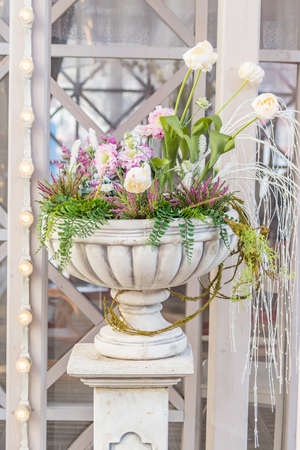Blooming flowers in a large vase in the street on a sunny day, wedding decorationの写真素材