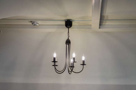 vintage chandelier hanging under white ceiling with stucco moldings