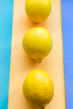topv view of three lemons on colorful pastel backgroundの写真素材