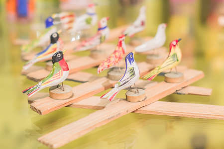 wooden toy in shape of birds on glass shelfの写真素材