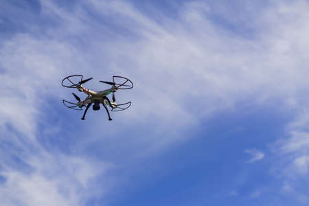 flying drone with remote control against blue sky background.