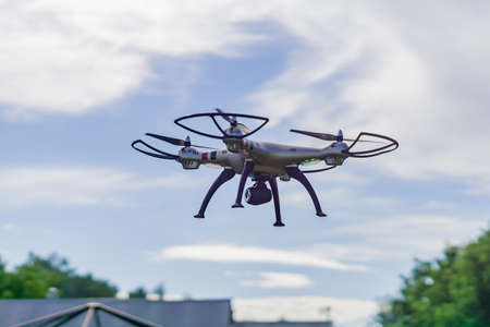 flying drone with remote control against blue sky background.