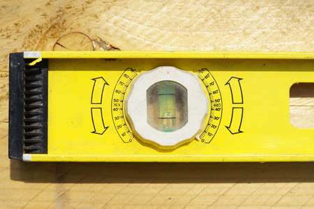 Yellow building level . working tool on wooden background