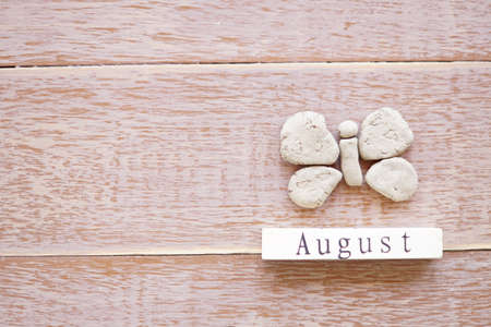top view of wooden calendar with August sign, clay butterflyの写真素材