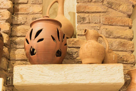 clay jars on a stone shelf in orient room. close up